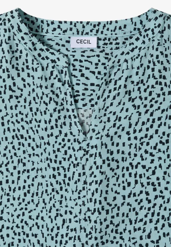 Türkisfarbenes Damenoberteil mit V-Ausschnitt und schwarzem Fleckenmuster, Label 'CECIL'.