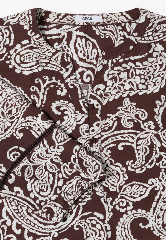 Bruine wikkeltop met witte paisleyprint en gedraaide knoop aan de voorkant.
