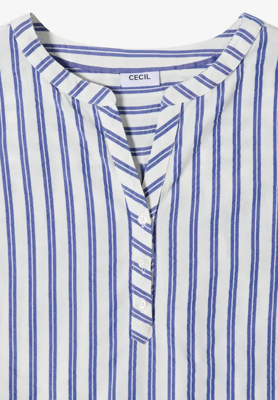 Blouse blanche à fines rayures bleues verticales, encolure ronde et patte de boutonnage, étiquette "CECIL" visible.
