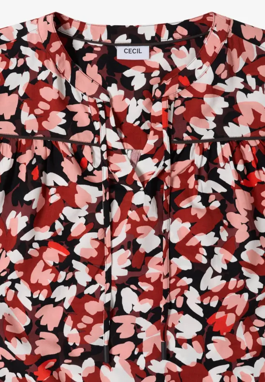 Rote Bluse mit floralen Mustern in Rosa, Weiß und Schwarz.