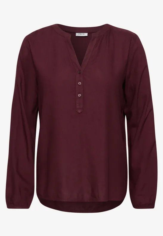 Bordeauxrode damesblouse met lange mouwen, V-hals en knoopsluiting, losse pasvorm.