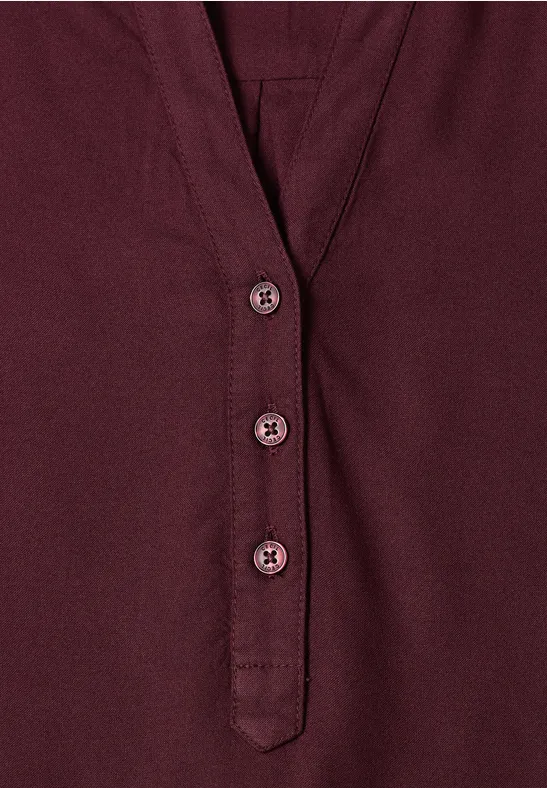 Bordeauxrood shirt met V-hals en drie bijpassende knopen.