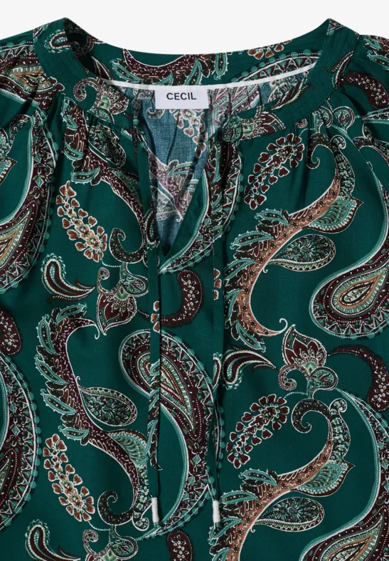 Grüne Bluse mit Paisley-Muster und Bindeband am Ausschnitt.