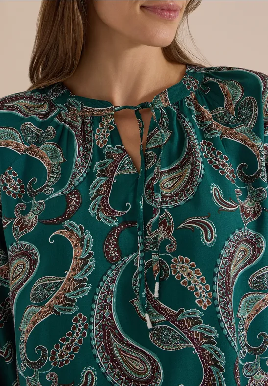 Grüne Bluse mit Paisley-Muster und bindbarem Schlüsselloch-Ausschnitt.