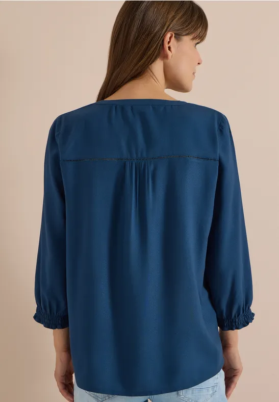 Frau von hinten in locker sitzender, blauer Bluse mit 3/4-Ärmeln