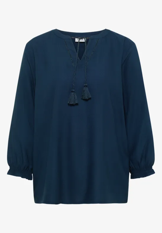 Dunkelblaue Bluse mit langen Ballonärmeln und V-Ausschnitt mit dekorativen Quasten.