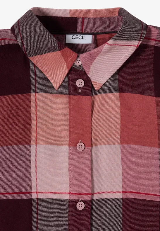 Gros plan d’une chemise à carreaux rose, rouge et marron avec boutons et col pointu.