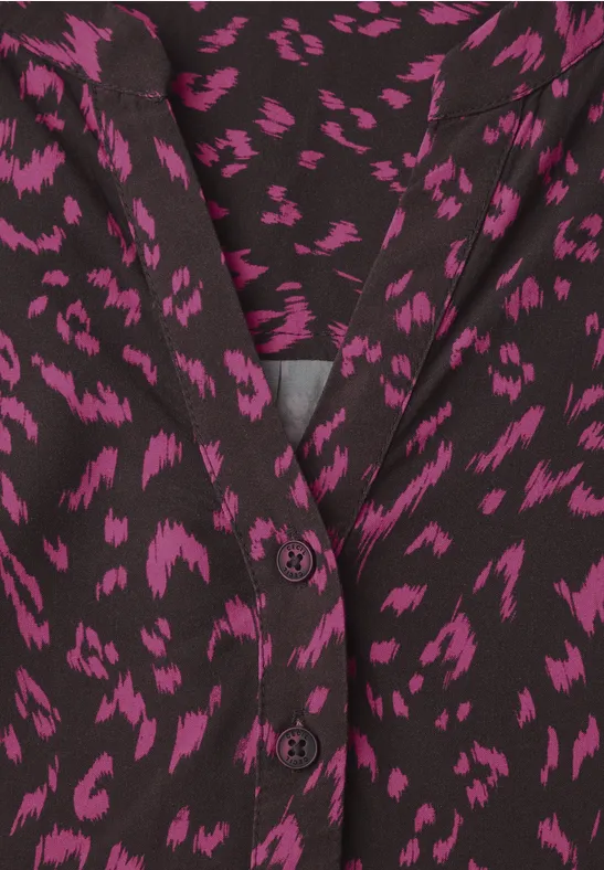 Schwarze Bluse mit unregelmäßigem pinken Leopardenmuster und V-Ausschnitt, zweireihige Knopfleiste.