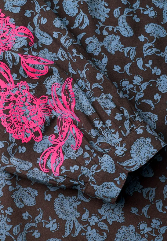 Nahaufnahme eines braunen Stoffes mit blauem Blumenmuster und pinker Blumenstickerei.