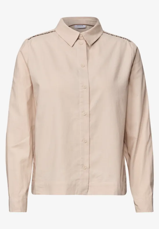 Une chemise beige simple en coton avec boutonnière et col.