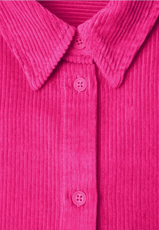 Nahaufnahme eines pinkfarbenen Cordhemds mit Kragen und Knöpfen.