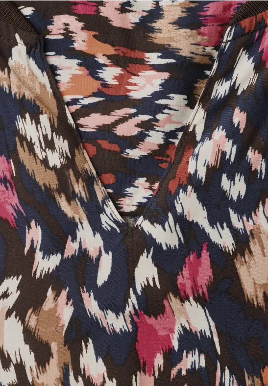 Tissu coloré à motif animalier abstrait en tons marron, bleu marine, blanc et rose, texture subtile.