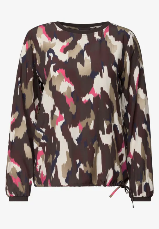 Langärmliger Pullover mit abstraktem Camouflage-Muster in Erdtönen und pinken Akzenten.
