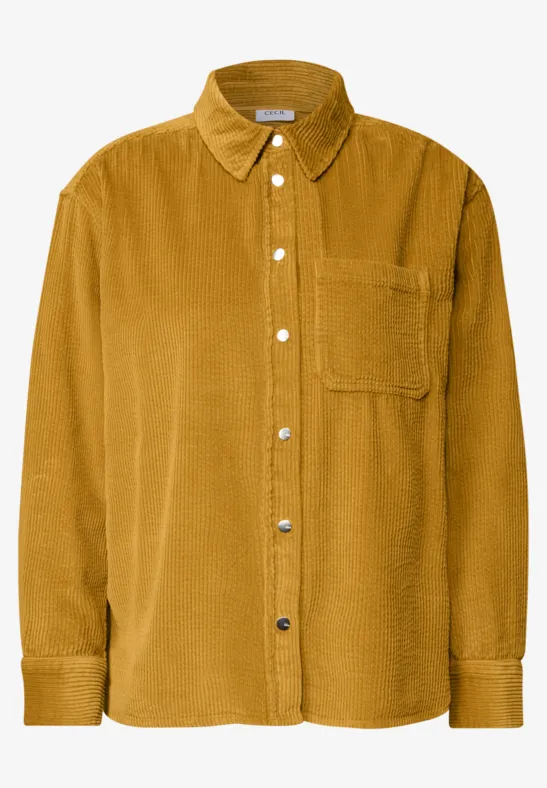 Chemise en velours côtelé moutarde avec patte de boutonnage et poche poitrine.