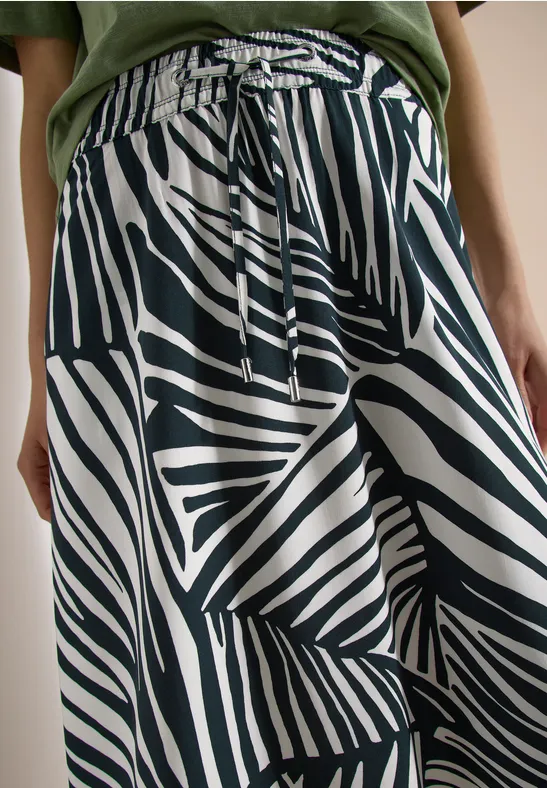 Loszittende broek met zwart-witte zebraprint, elastische tailleband en koordsluiting.