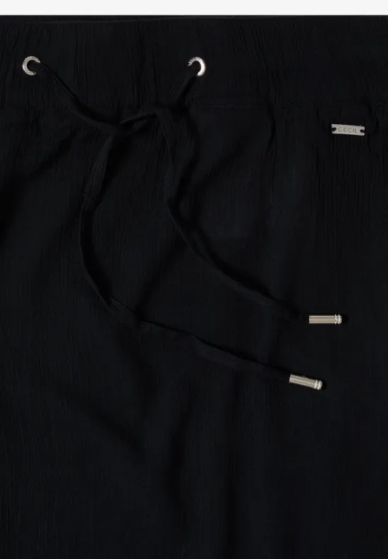 Schwarze Stoffhose mit Kordelzug und silbernen Metallenden.