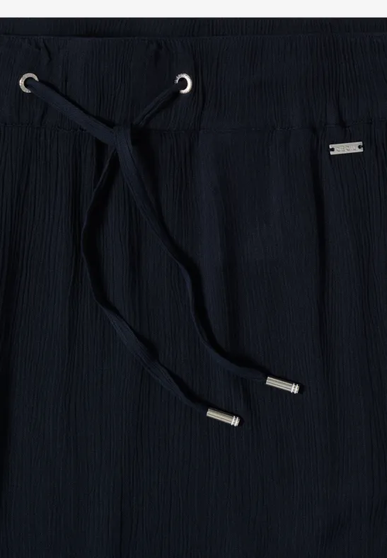 Dunkelblaue Hose mit elastischem Bund und Kordelzug, gerippte Textur und silberne Enden an den Schnürsenkeln.