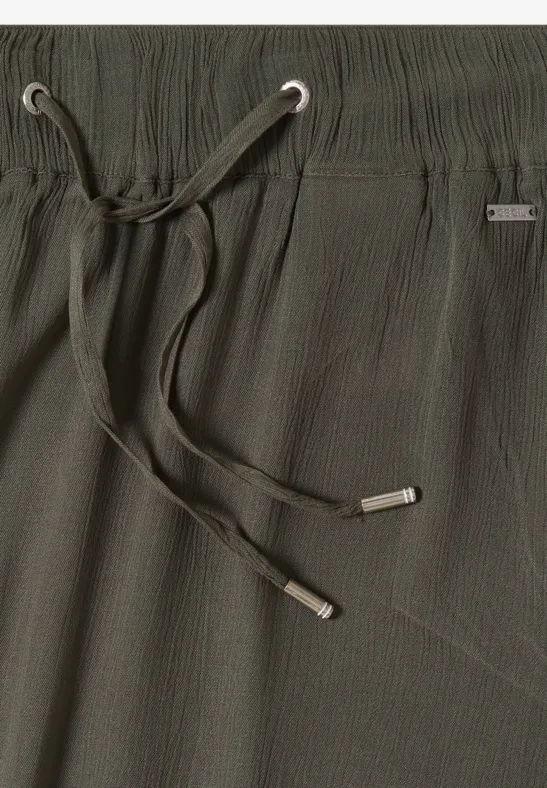 Dunkelgrüne, strukturierte Hose mit elastischem Bund, silbernen Ösen und lässigem Kordelzug.
