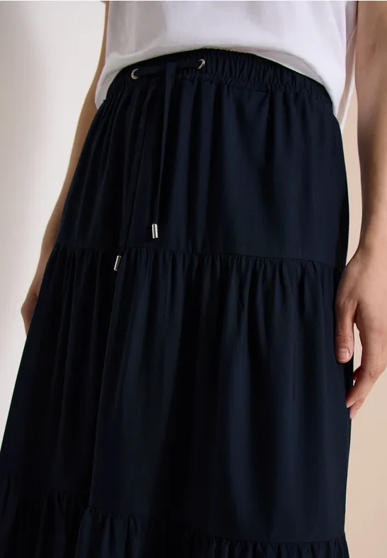 Jupe midi bleu marine à volants avec taille élastique et lien.