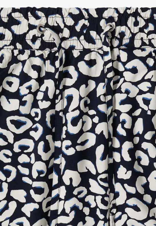 Elastisch geraffter dunkelblauer Stoff mit weißem, abstraktem Leopardenmuster.