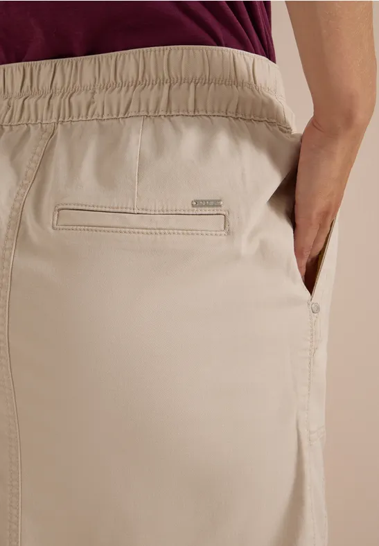 Beige Hose mit elastischem Bund, verdeckter Gesäßtasche und seitlicher Eingriffstasche.