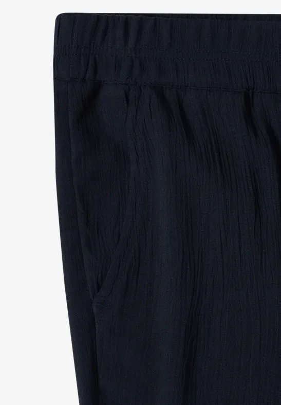 Zwarte, gestructureerde broek met elastische tailleband en zijzakken.