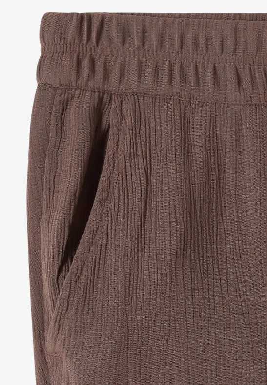 Bruine broek met elastische taille, gestructureerde stof en zijzak.