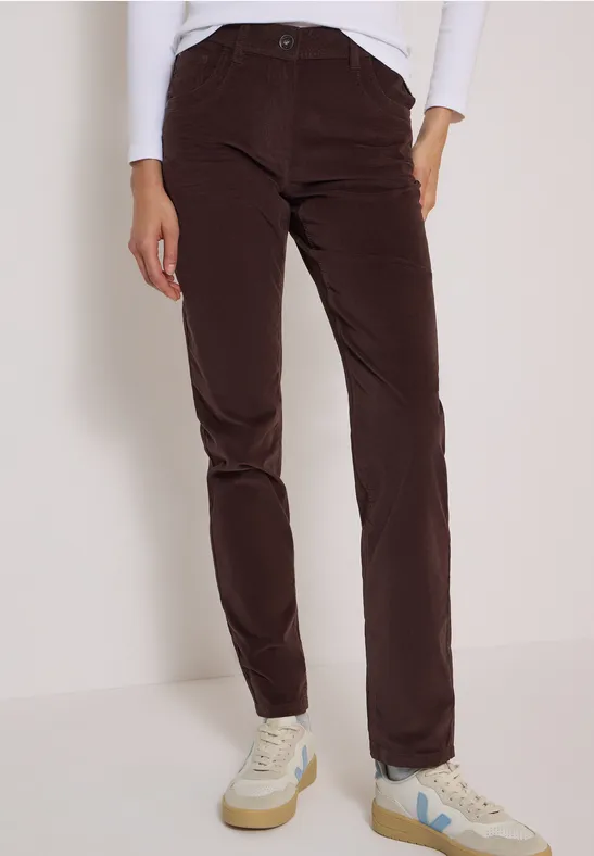 Braune Cordhose mit geradem Schnitt, kombiniert mit weißen Sneakern.