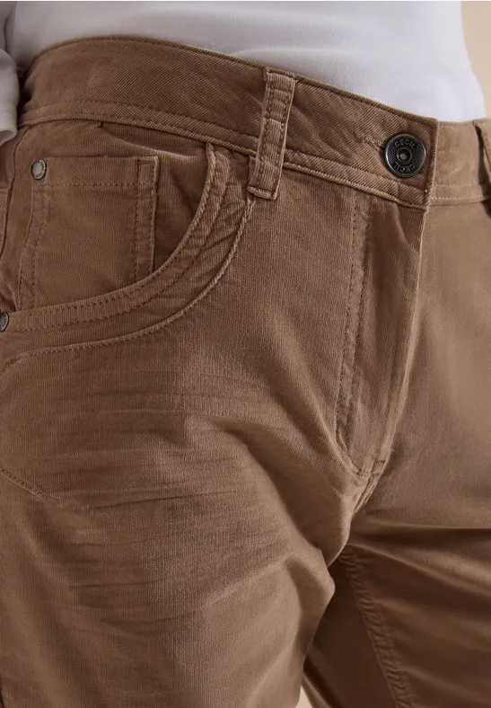 Nahaufnahme einer Person in brauner Hose und weißem Oberteil