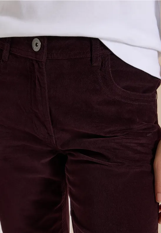 Pantalon en velours côtelé bordeaux à taille haute avec poches, associé à un t-shirt blanc