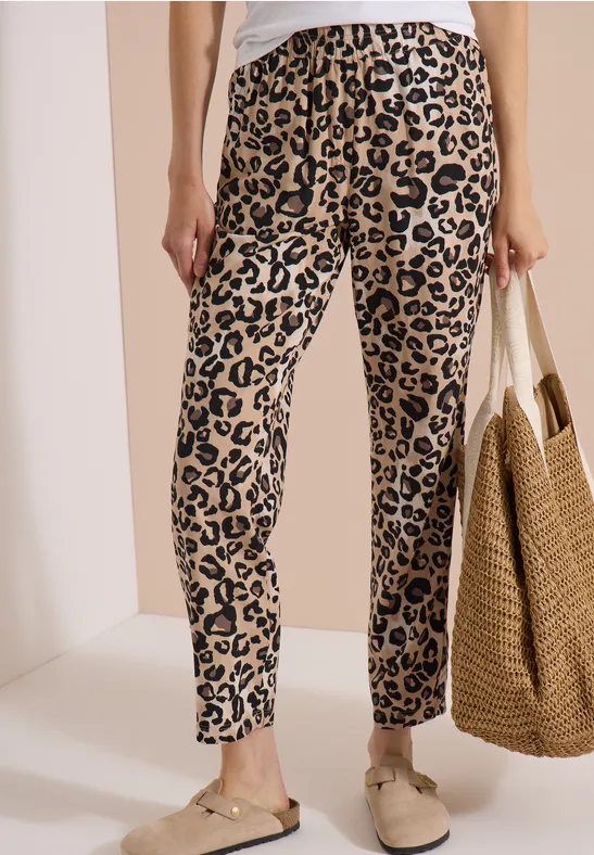 Leichte Damenhose mit Leopardenmuster, dazu Basttasche und bequeme Slipper