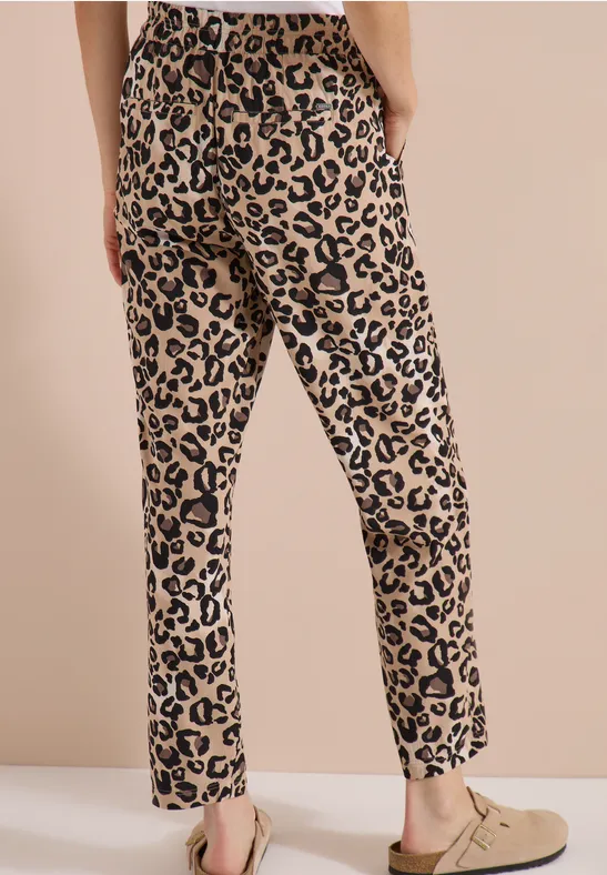 Hose mit Leopardenmuster, geradem Bein, leicht tailliert und mit beigen Slippern kombiniert.
