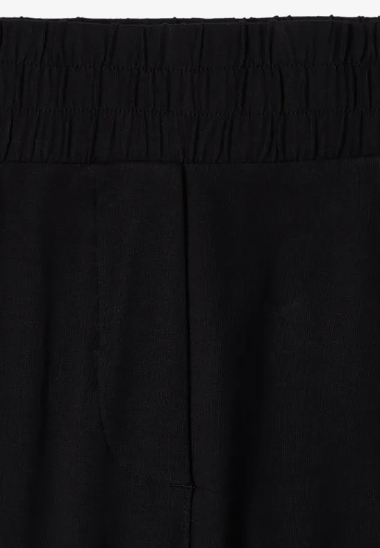 Schwarze Leggings mit hohem, elastischem Bund aus dehnbarem Jersey-Stoff.