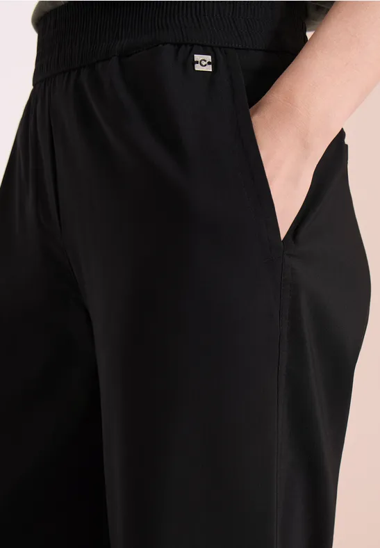 Zwarte joggingbroek met elastische taille en hand in de zijzak.