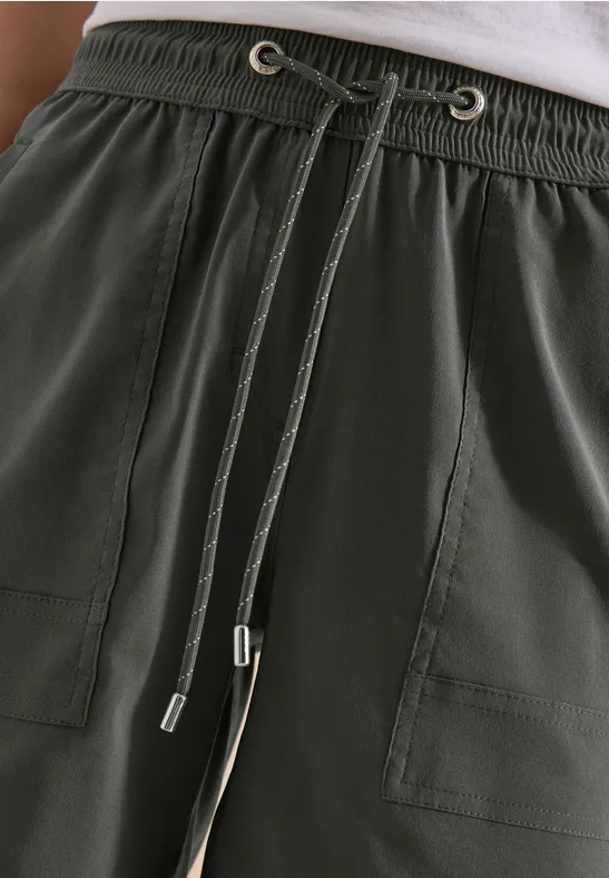 Donkergroene broek met elastische taille, zichtbare trekkoorden en opgestikte zakken