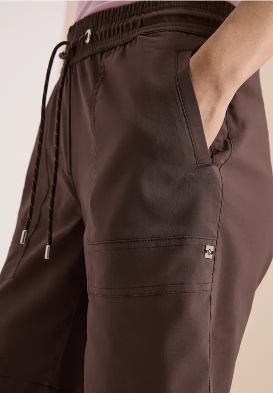 Bruine vrijetijdsbuk met elastische taille, koordsluiting en zijzakken, casual model.