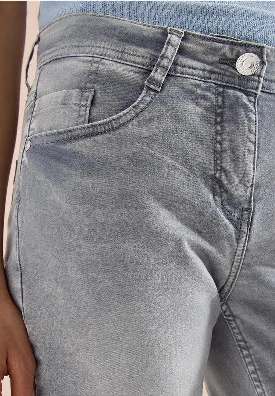 Nahaufnahme einer grauen Jeanshose mit Taschen und Knopfverschluss.