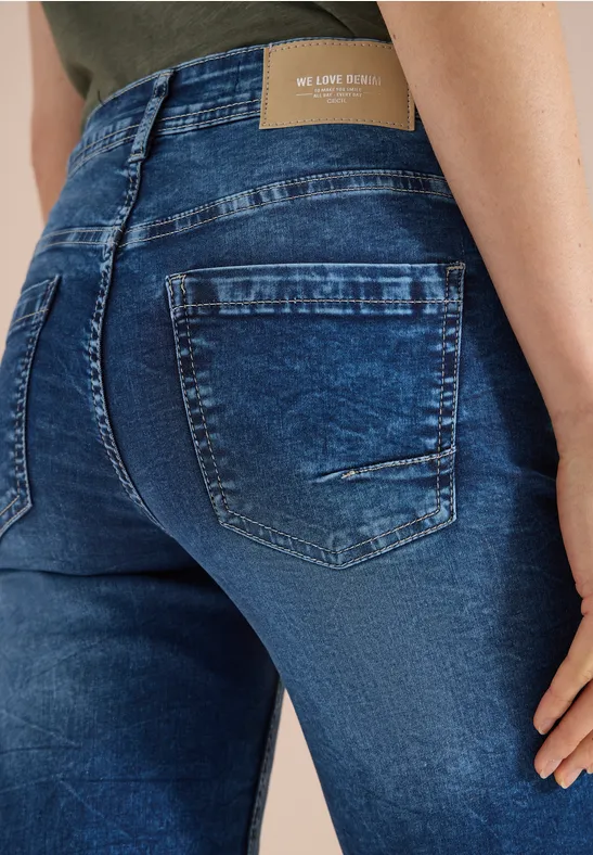 Eine Person von hinten trägt eng anliegende, dunkelblaue Jeans mit Taschen und leichtem Used-Look.