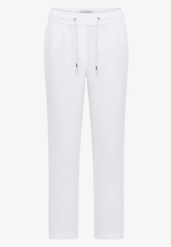 Weiße Jogginghose mit Kordelzug und seitlichen Taschen.