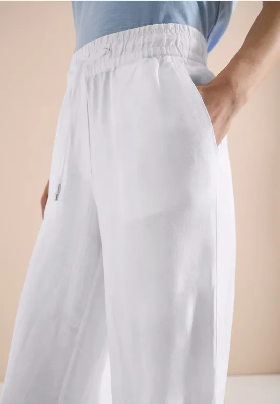 Weiße, weite Leinenhose mit Gummibund und Seitentaschen.
