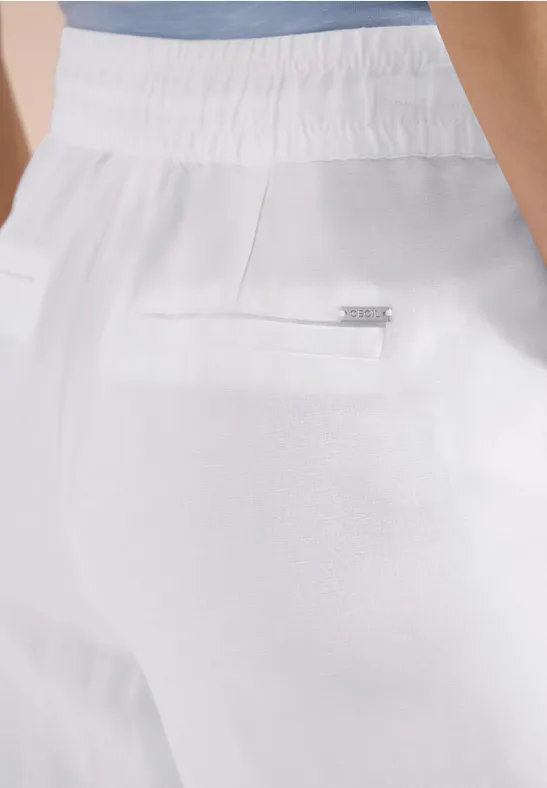 Weiße Hose mit elastischem Bund und Reißverschlusstasche am Gesäß, darüber hellblaues Oberteil.