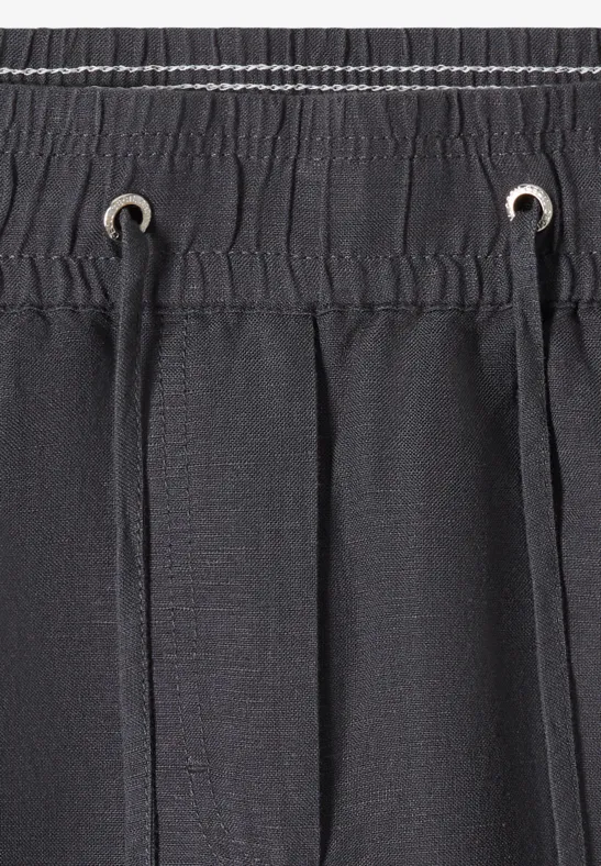 Dunkelgrauer elastischer Bund mit Kordelzug und Metallösen an einer Hose oder Badeshorts.