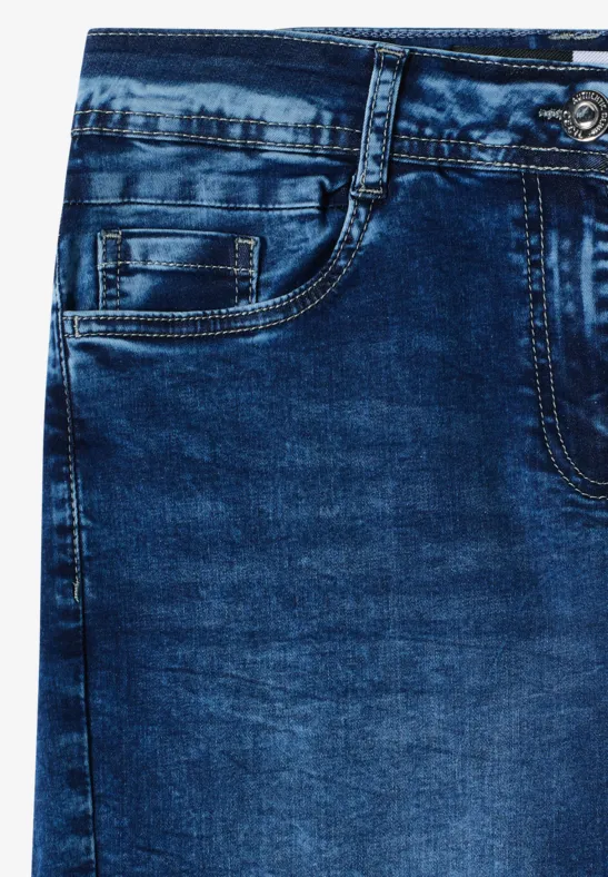 Nahaufnahme einer blauen Jeanshose mit Fronttasche, Gürtelschlaufen und sichtbarer Nahtstruktur.