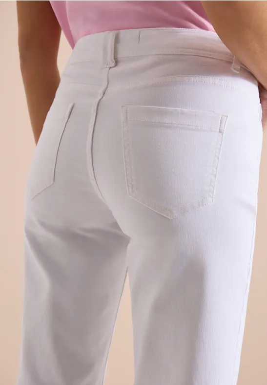 Close-up van billen in witte spijkerbroek en roze top.