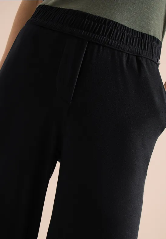 Schwarze, lockere Jogginghose mit elastischem Bund und seitlichen Taschen