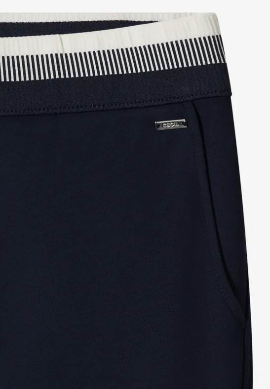 Pantalon de sport bleu foncé avec taille rayée, poche latérale et petit logo métal