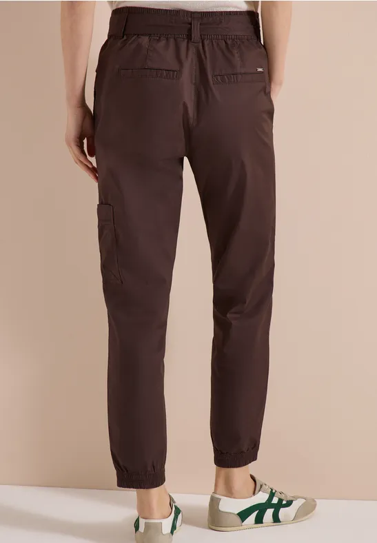 Rückansicht einer dunkelbraunen Cargo-Hose mit elastischem Saum, getragen zu weißen Sneakern.