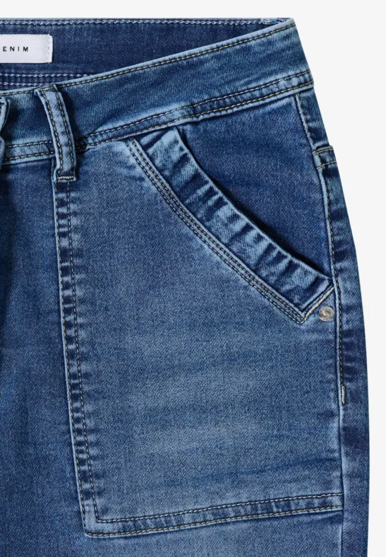 Nahaufnahme einer blauen Jeans mit Gürtelschlaufen, Saumnaht und aufgesetzter Tasche.