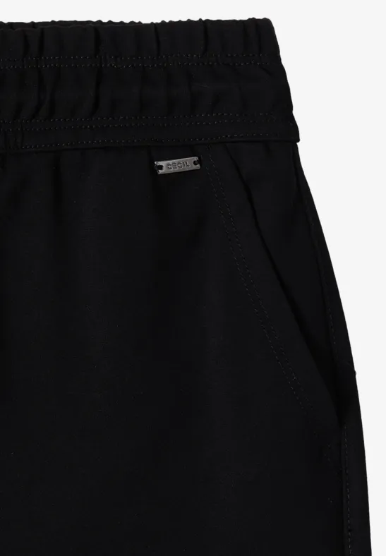 Schwarze, elastische Jogginghose mit hohem Bund, seitlicher Eingrifftasche und kleinem Metall-Label.