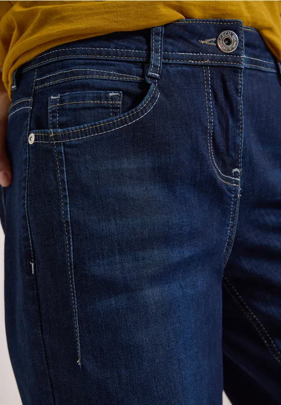 Nahaufnahme einer dunkelblauen Jeans mit Hosentaschen und sichtbarer Nahtgestaltung.